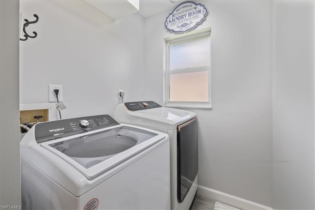 Laundry room with washing machine and clothes dryer and baseboards