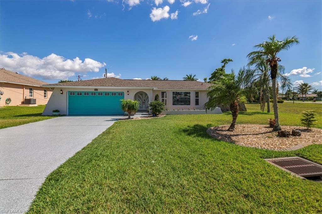 Single story home with stucco siding, an attached garage, driveway, and a front lawn