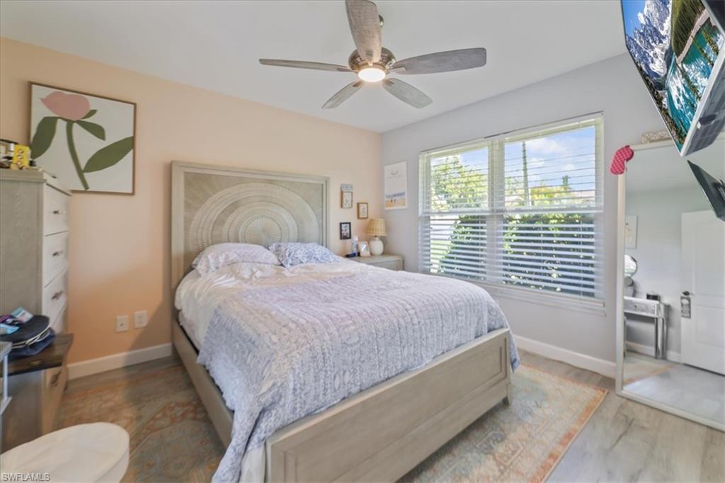 Bedroom with wood finished floors, baseboards, and a ceiling fan