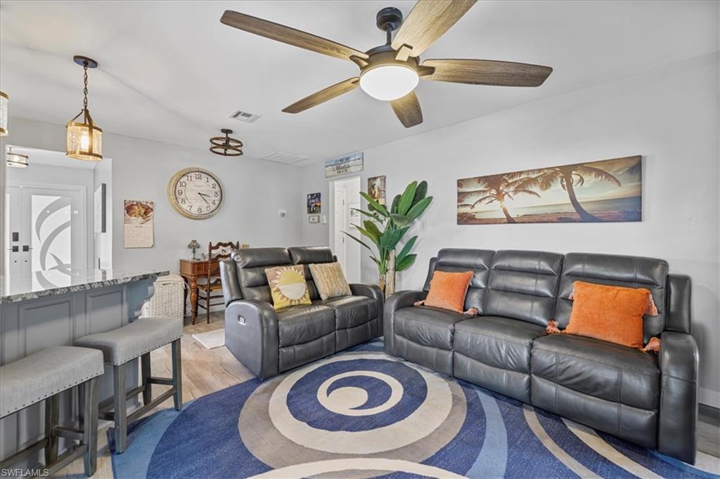 Living room with a ceiling fan and light wood-type flooring