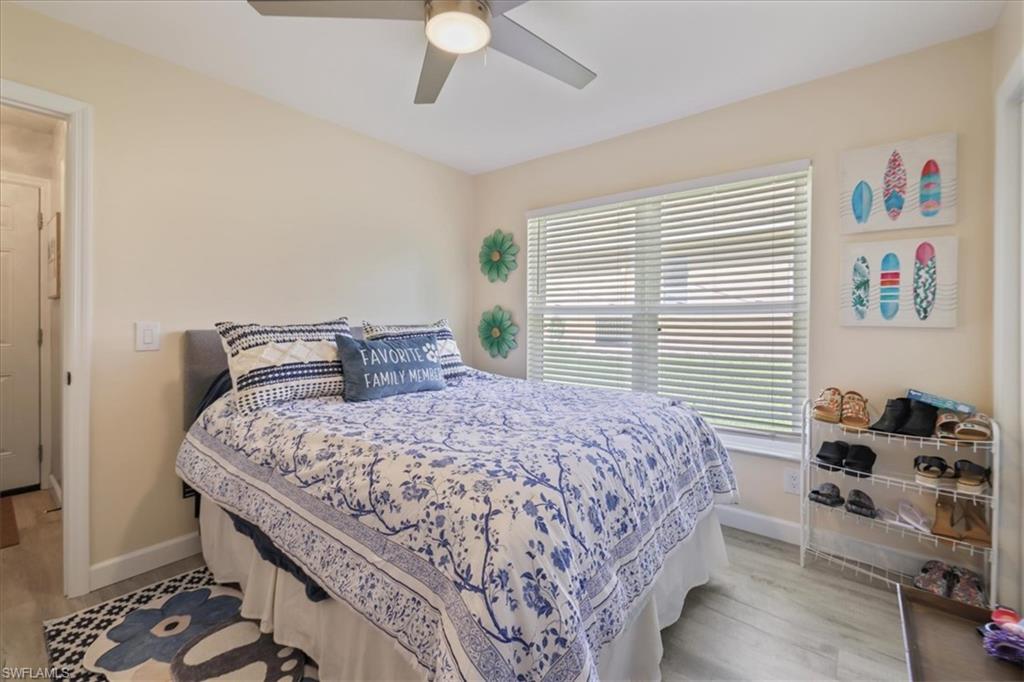 Bedroom with multiple windows, baseboards, and light wood-style floors