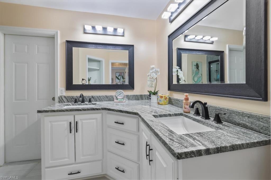 Full bath featuring double vanity and tile patterned floors