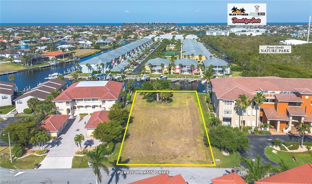 Aerial view of residential area featuring a nearby body of water and property boundaries highlighted