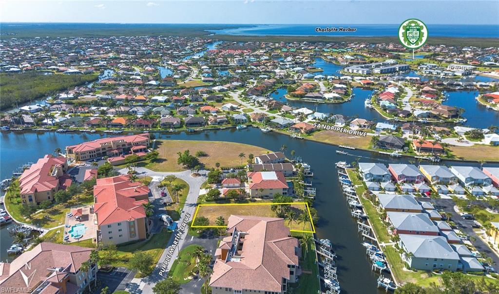 Aerial perspective of suburban area with a nearby body of water and property boundaries highlighted