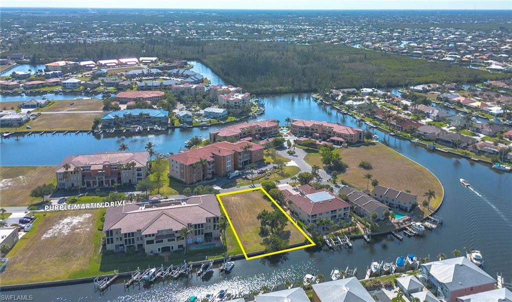 Aerial view of residential area with a nearby body of water and property parcel outlined