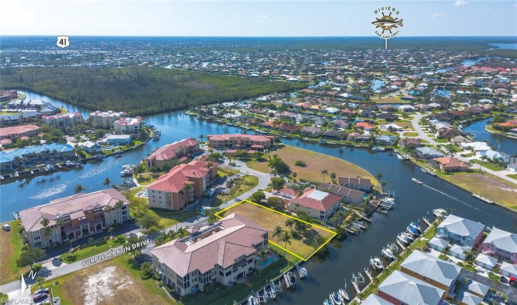 Aerial view of residential area with a nearby body of water and property parcel outlined