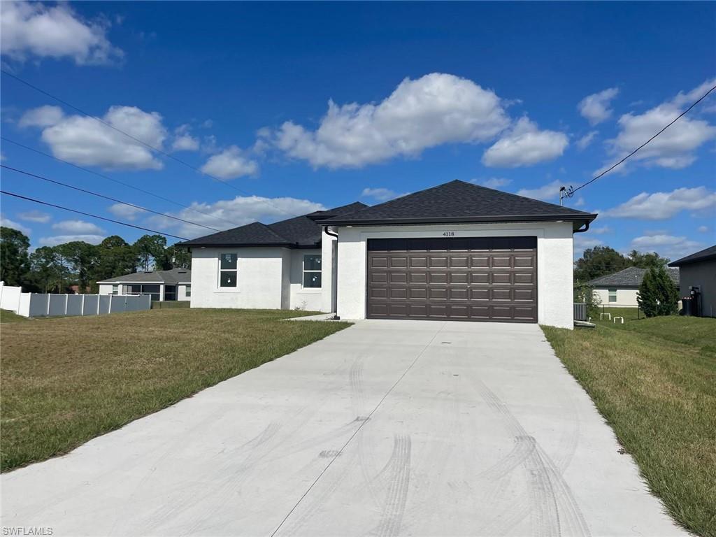 View of front of home featuring stucco siding, a garage, and concrete driveway