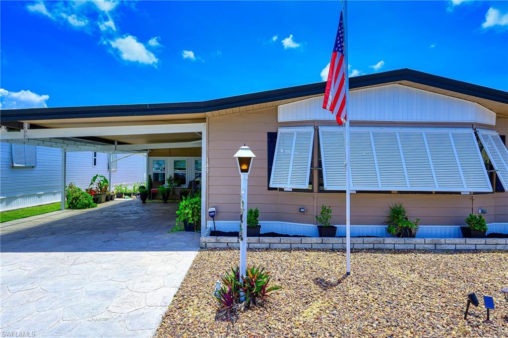 Manufactured / mobile home featuring concrete driveway and a carport