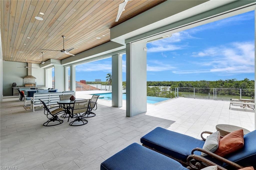 View of patio / terrace with a ceiling fan, an outdoor kitchen, fence, and outdoor dining space