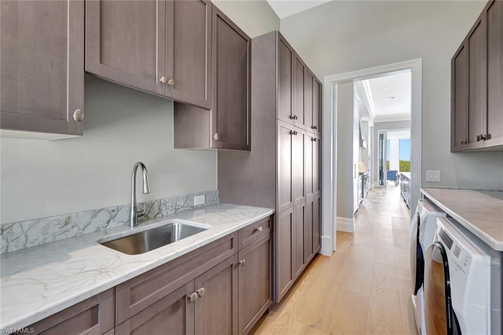 Laundry room with a sink, washing machine and clothes dryer
