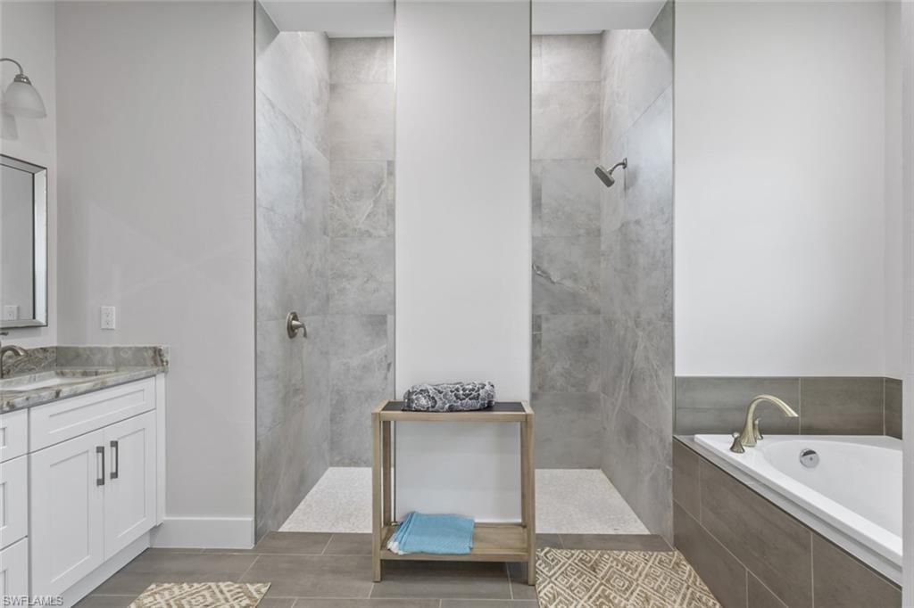 Bathroom with vanity, walk in shower, and a bath