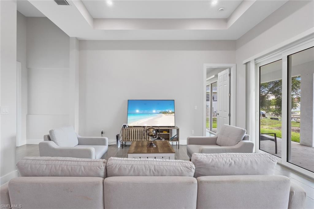 Living room featuring a tray ceiling and recessed lighting