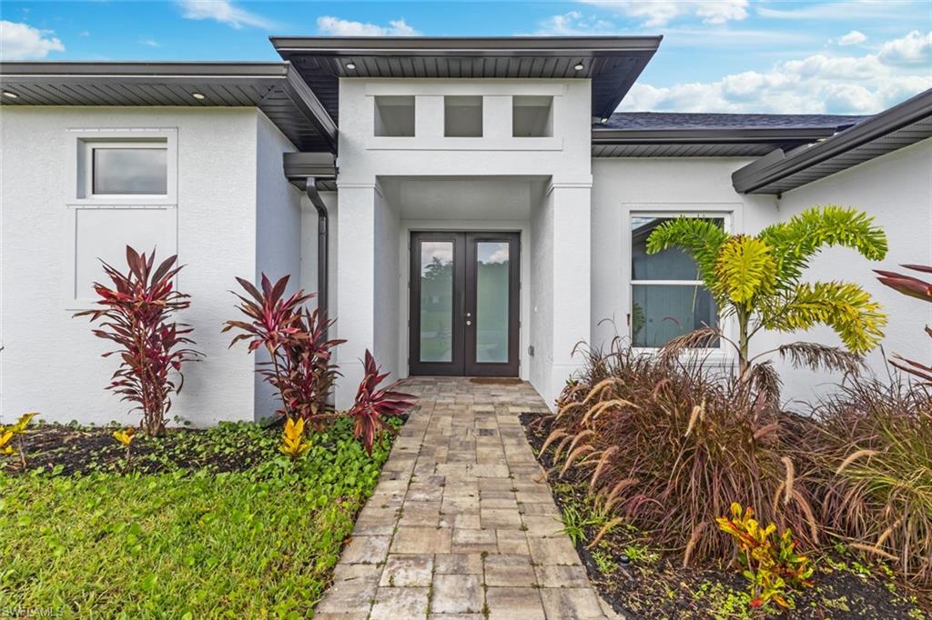 Property entrance with french doors and stucco siding