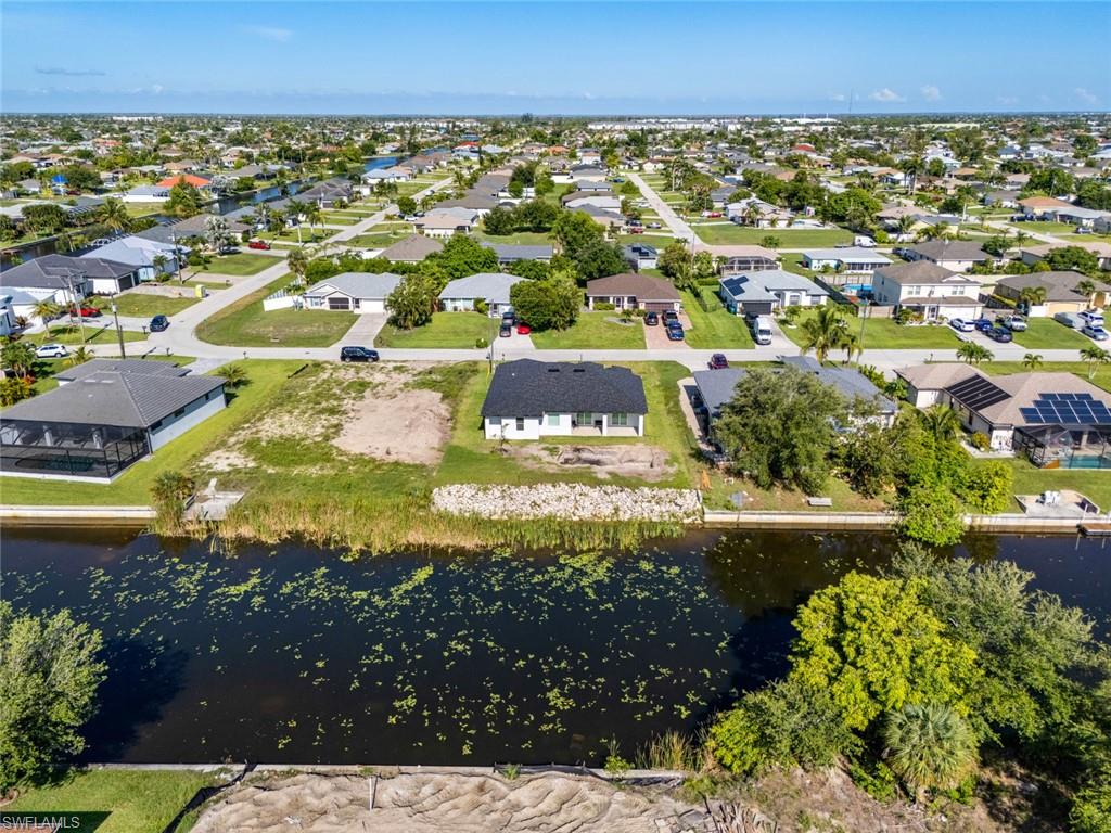 Aerial perspective of suburban area featuring a nearby body of water
