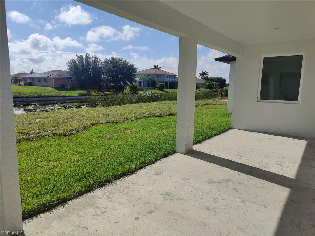 View of grassy yard with a patio area, a residential view, and a water view
