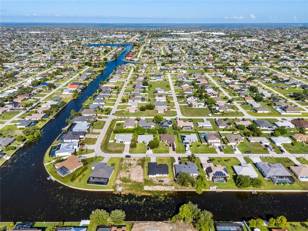 Aerial perspective of suburban area featuring a nearby body of water