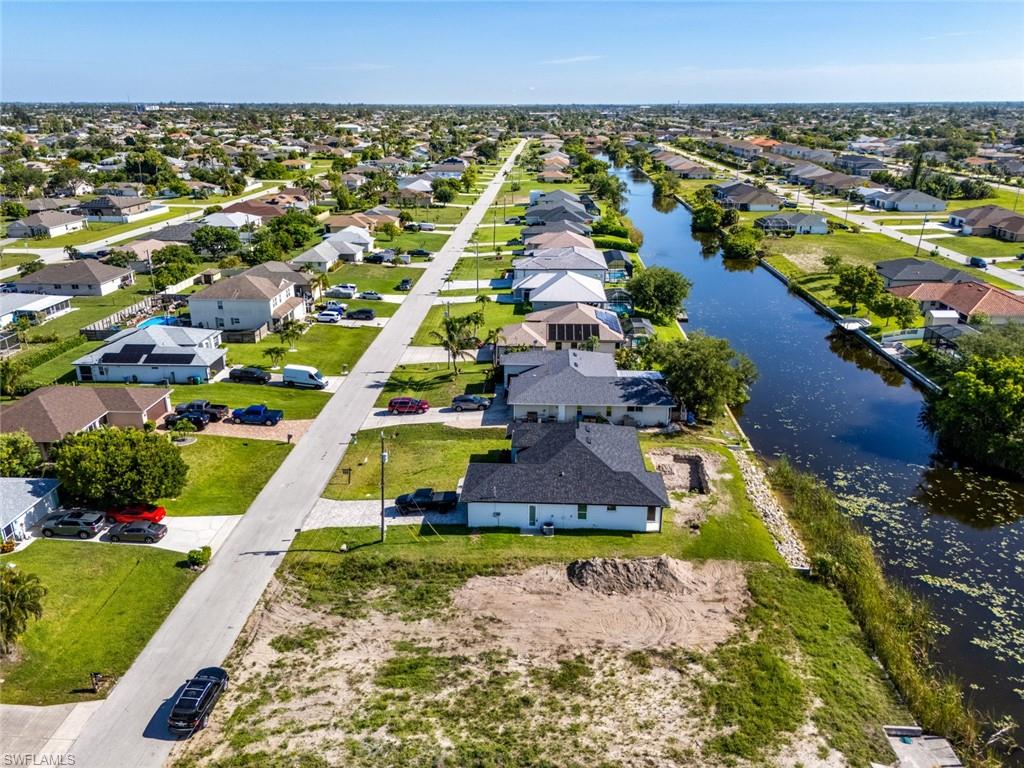 Aerial perspective of suburban area featuring a nearby body of water