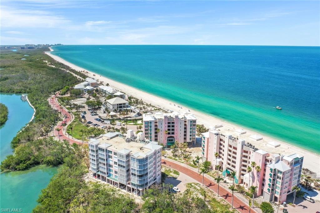 Drone / aerial view of apartment complex / building and waterfront with a beach