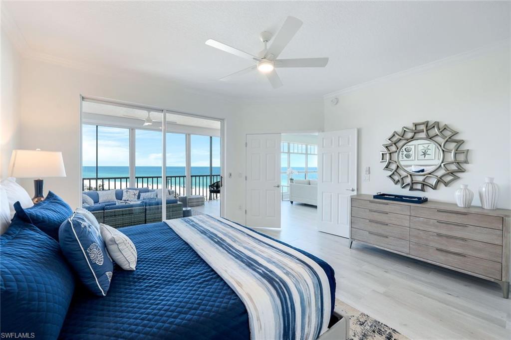 Bedroom featuring access to outside, light wood-type flooring, ornamental molding, a water view, and ceiling fan