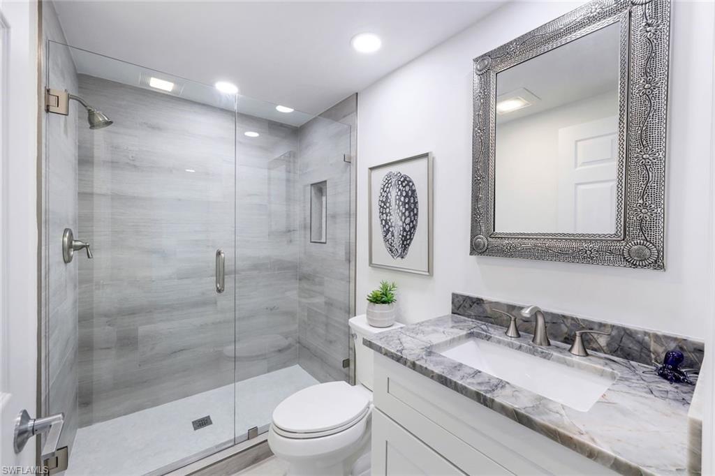 Bathroom with vanity, toilet, a shower stall, and recessed lighting