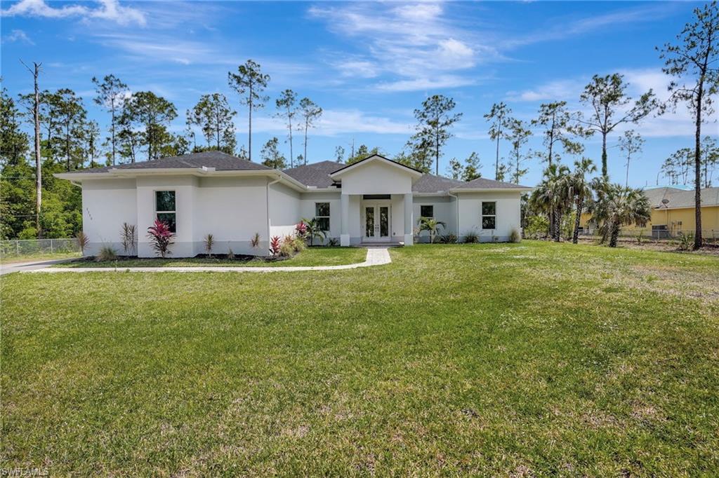 Ranch-style home with french doors, stucco siding, and roof with shingles