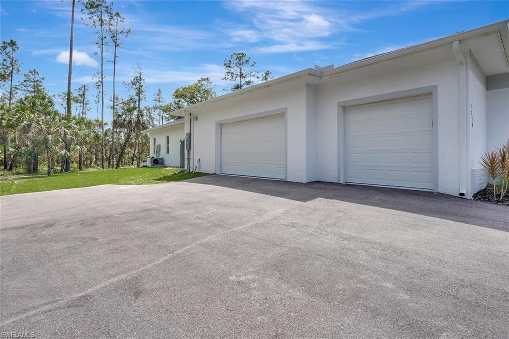 View of home's exterior with stucco siding, a garage, and driveway