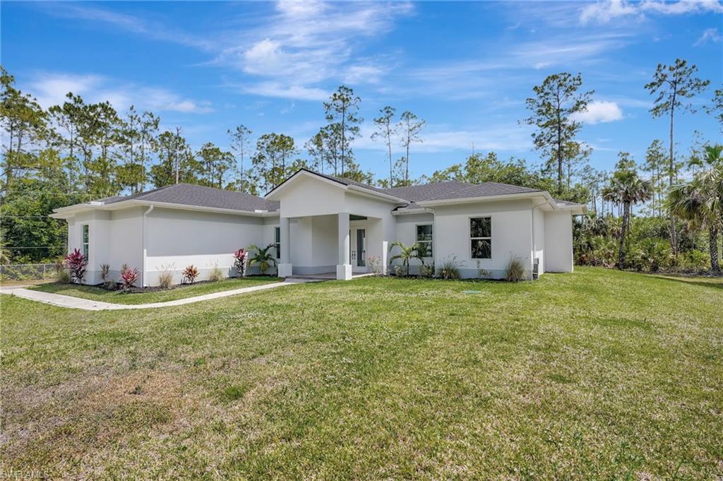 Ranch-style house with stucco siding and a front lawn