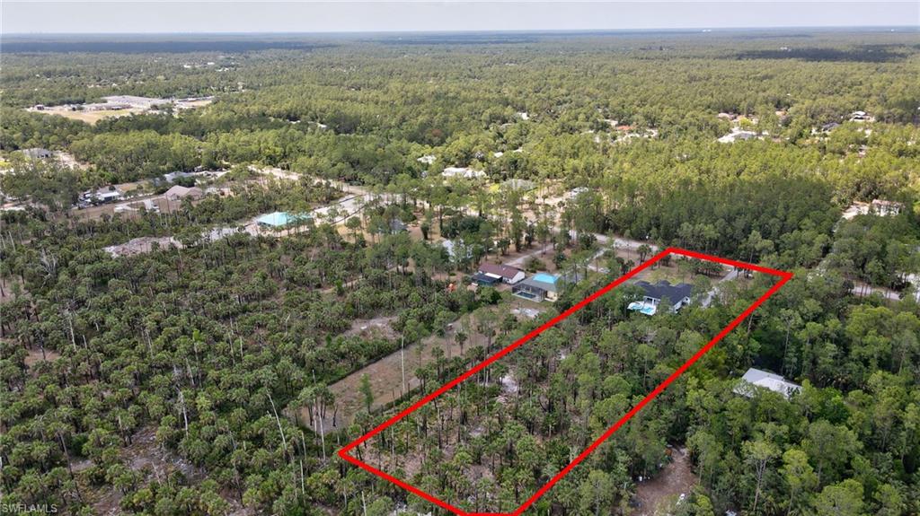 Aerial view of property's location with a heavily wooded area and property boundaries highlighted