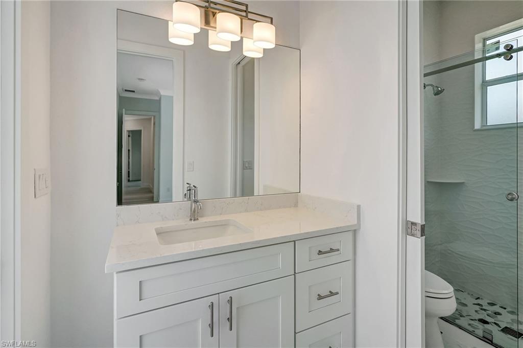 Bathroom with a stall shower, toilet, and vanity