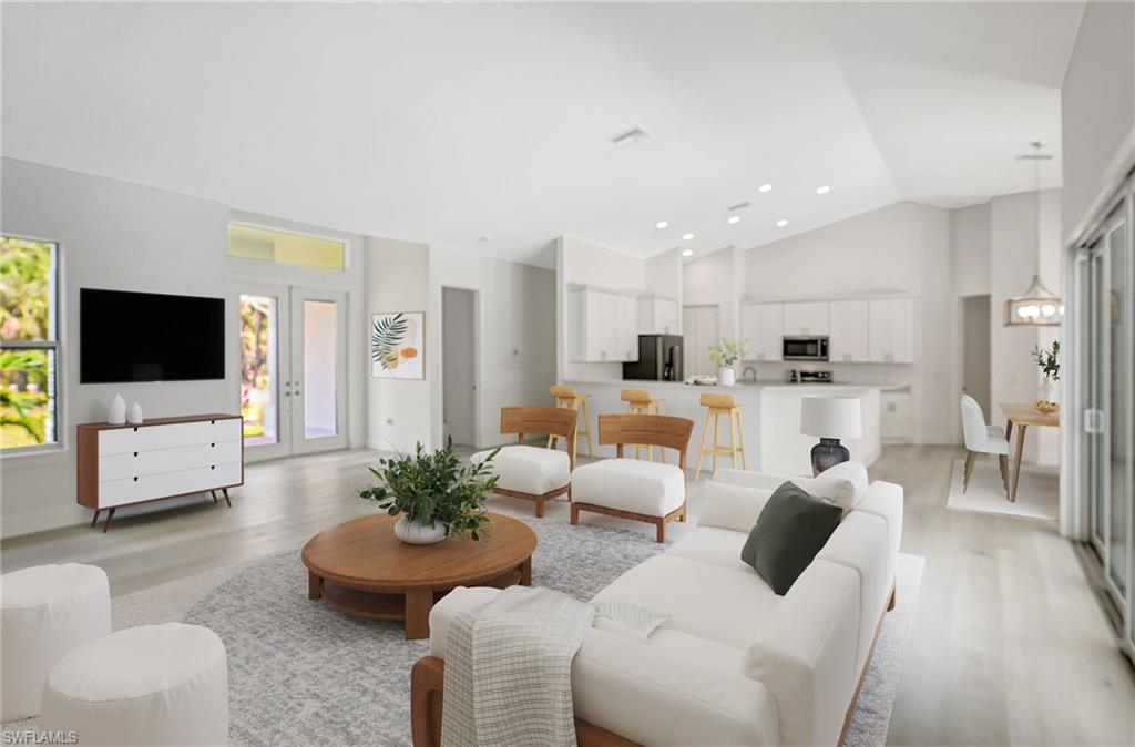 Living room with light wood-style flooring, high vaulted ceiling, and recessed lighting
