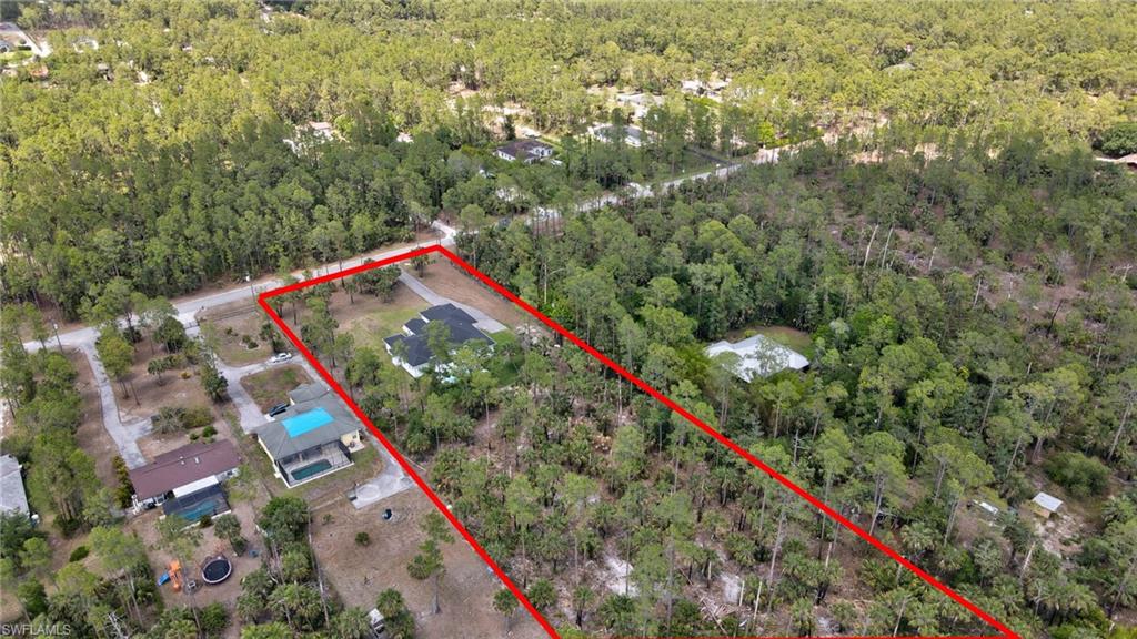 Aerial view of property's location with a heavily wooded area and property parcel outlined