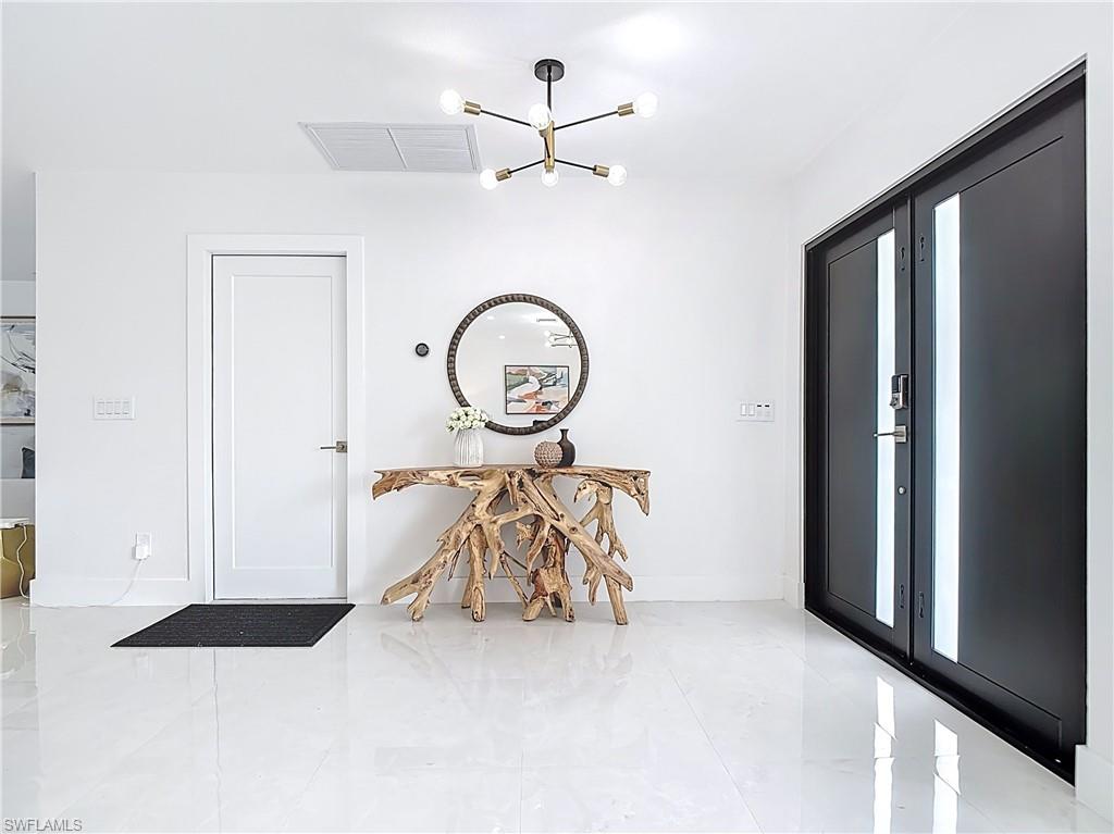 Foyer featuring a chandelier and baseboards