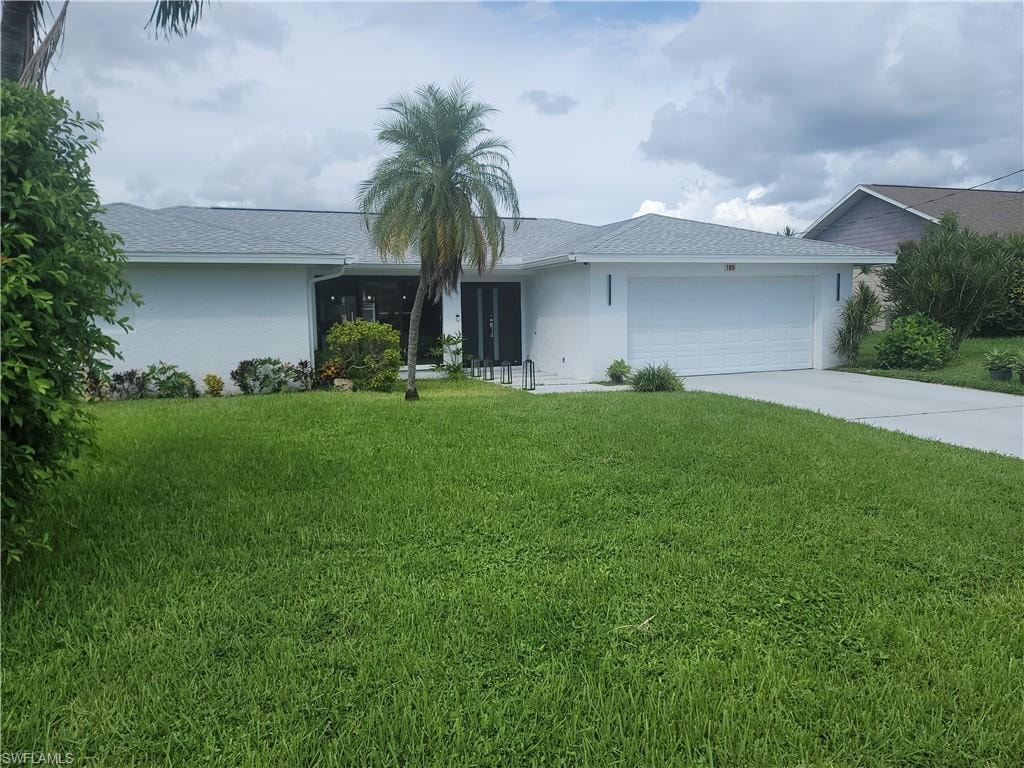 Ranch-style house featuring stucco siding, concrete driveway, a front lawn, and an attached garage