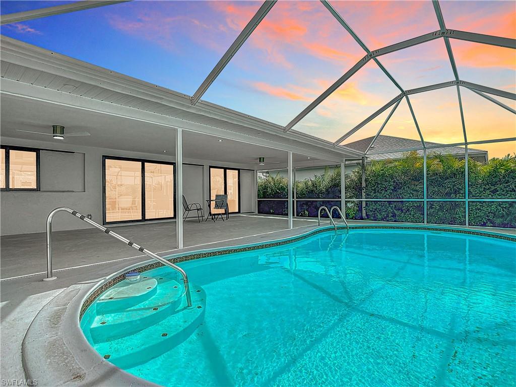 Outdoor pool with a patio and glass enclosure