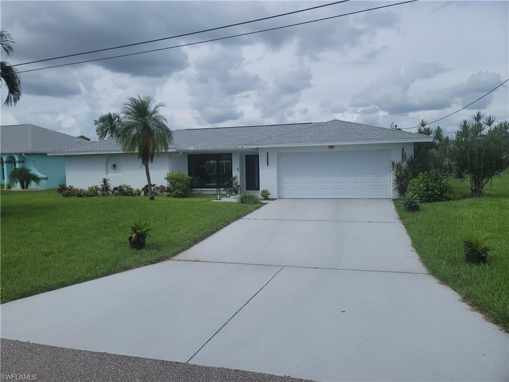 Single story home with driveway, a front yard, stucco siding, an attached garage, and a shingled roof