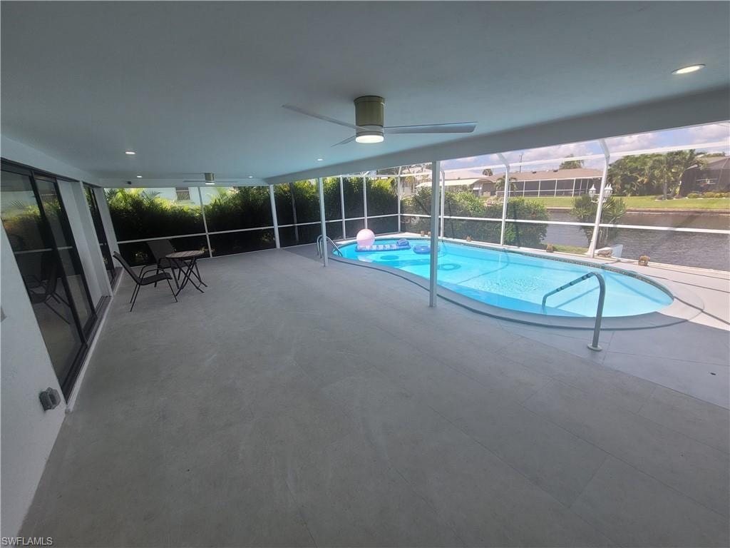 View of pool featuring a lanai, a sunroom, a patio area, and a ceiling fan