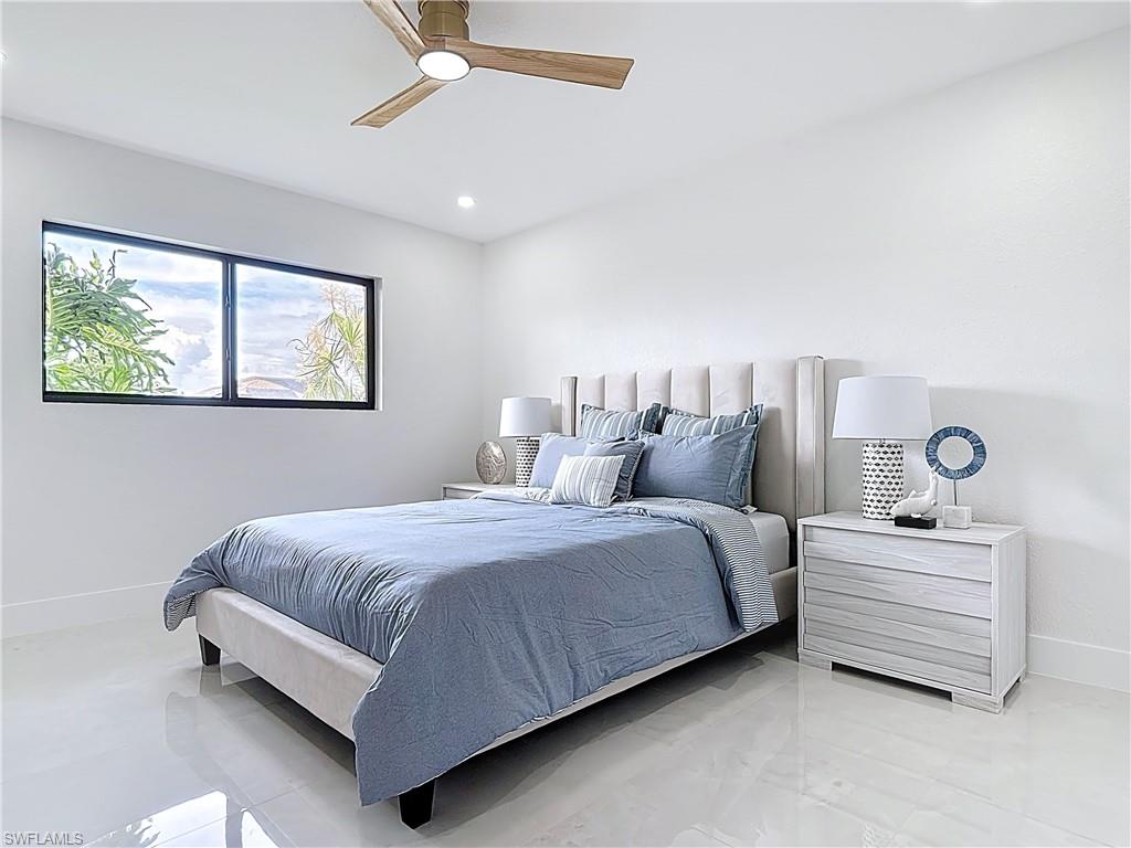 Bedroom featuring baseboards, a ceiling fan, light marble finish floors, and recessed lighting