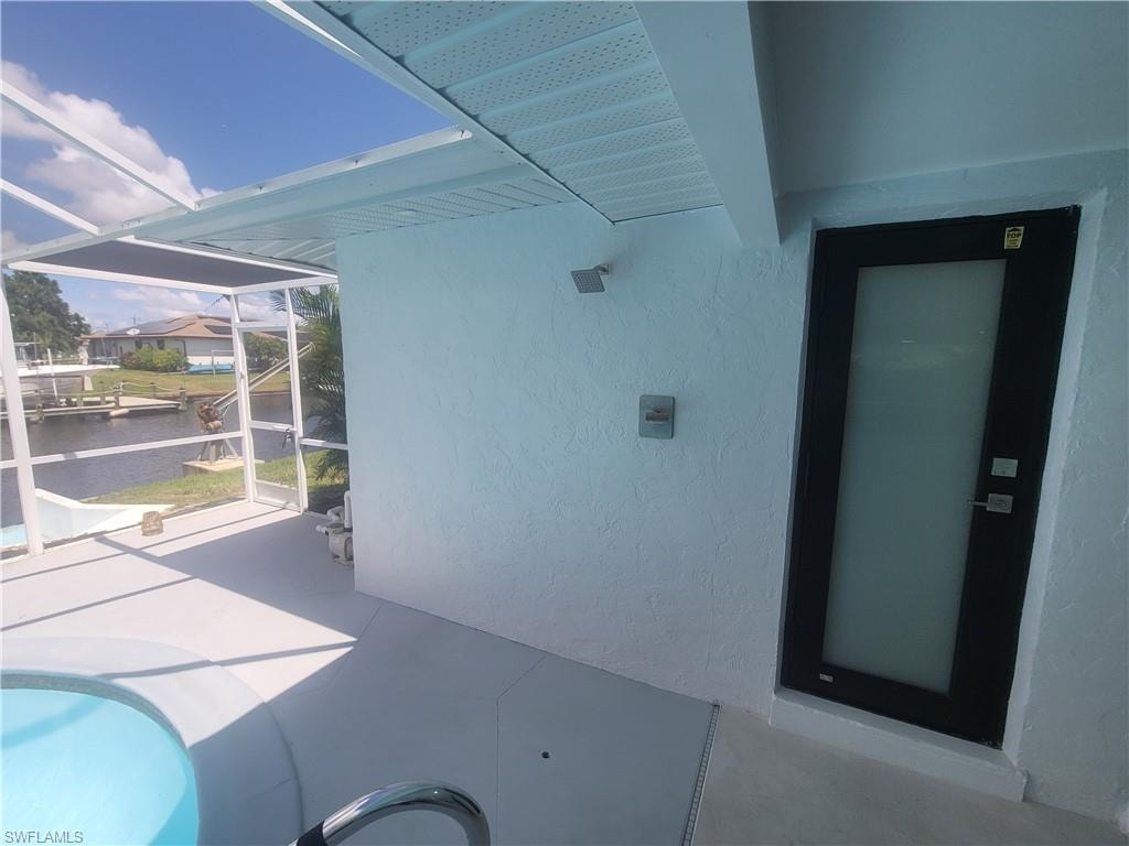 View of patio featuring a sunroom, an outdoor pool, and a water view
