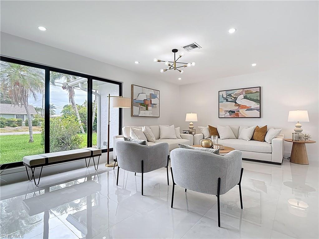 Living room with recessed lighting, a chandelier, and light tile patterned floors