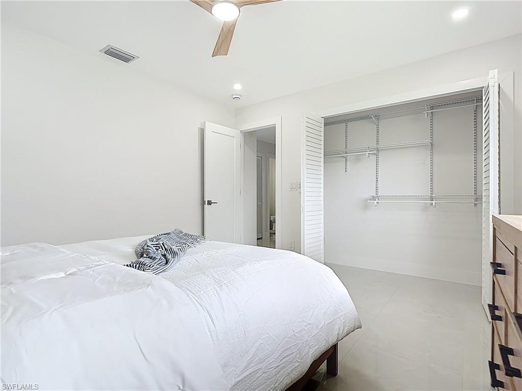 Bedroom featuring a closet, a ceiling fan, baseboards, and concrete floors