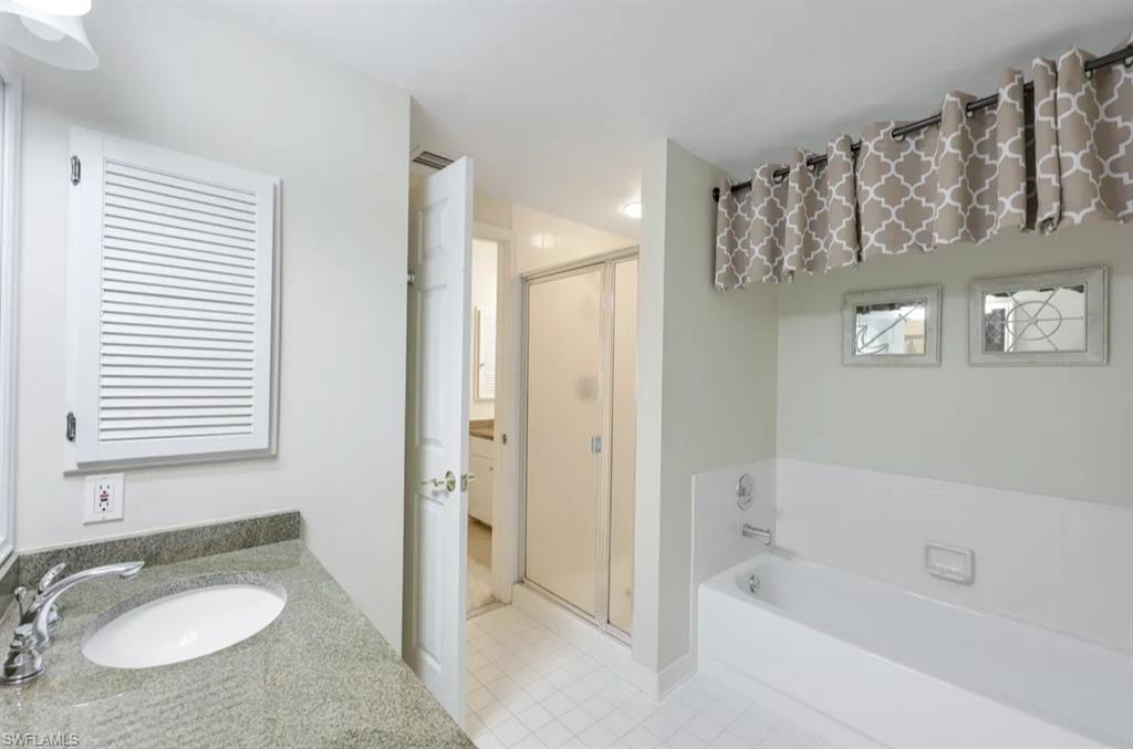 Full bath featuring a shower stall, tile patterned flooring, a bath, and vanity