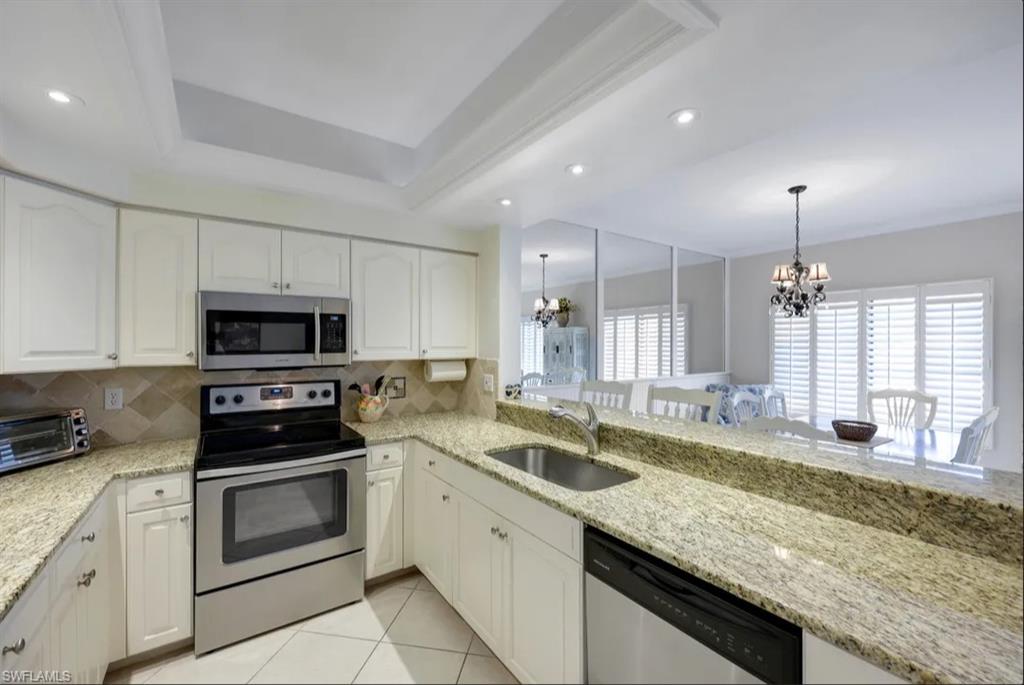 Kitchen featuring stainless steel appliances, a sink, a chandelier, backsplash, and recessed lighting