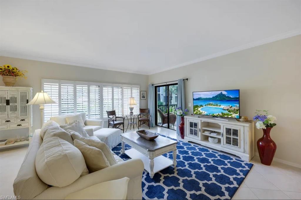 Tiled living area with crown molding and baseboards