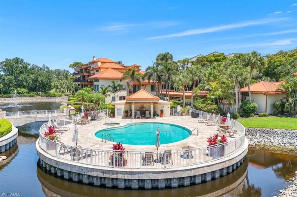 Community pool with a water view and a patio