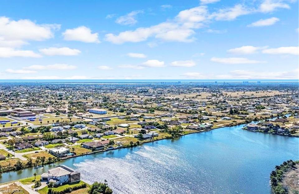 Aerial perspective of suburban area featuring a nearby body of water
