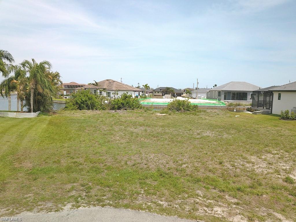View of green lawn with an outdoor pool and a residential view
