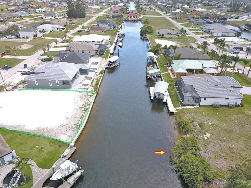 Aerial view of property's location featuring a nearby body of water and nearby suburban area