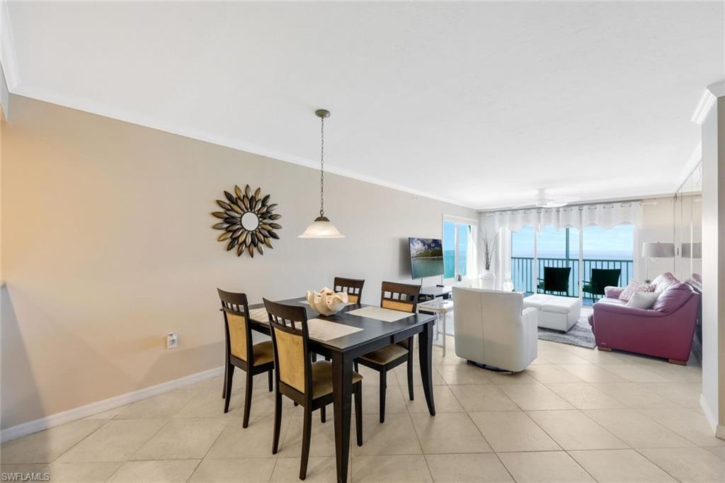 Dining space with ornamental molding and light tile floors