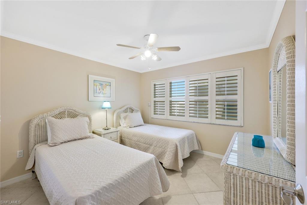 Bedroom featuring ceiling fan, light tile flooring, and crown molding