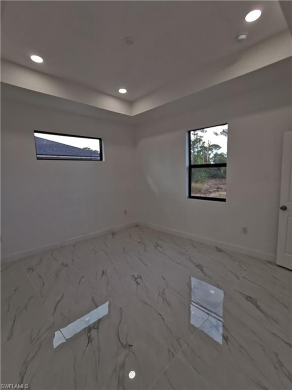Unfurnished room featuring recessed lighting and light marble finish flooring